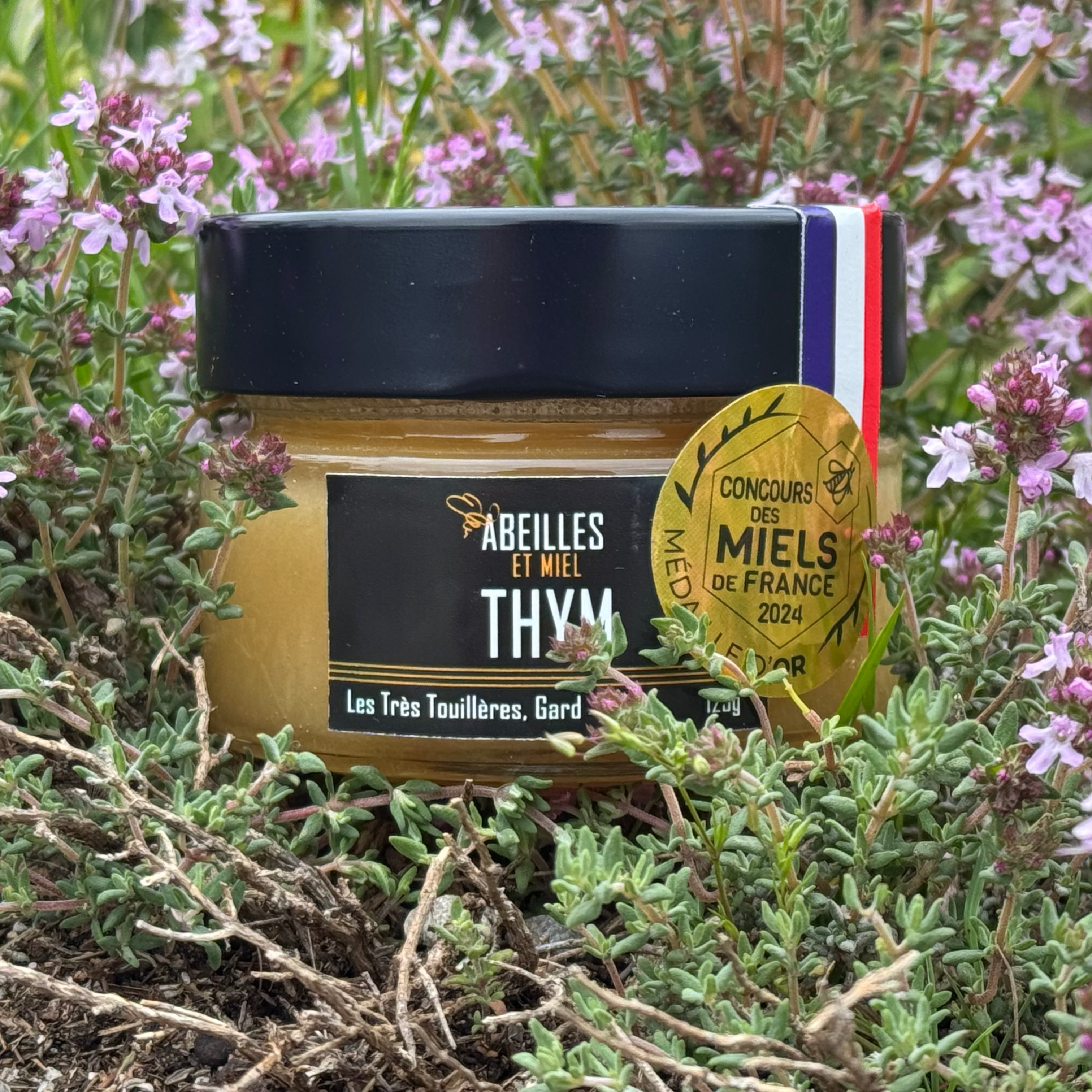 Miel de thym mis en scène avec des brins de thym